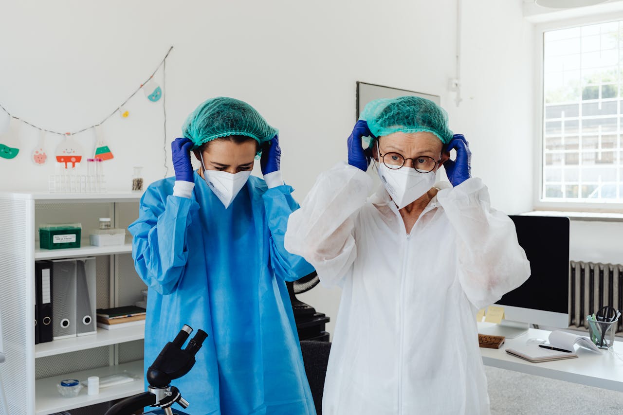Two healthcare professionals put on PPE in a laboratory, ensuring safety during work.